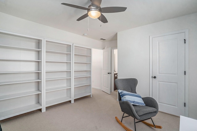 living area with ceiling fan and light carpet