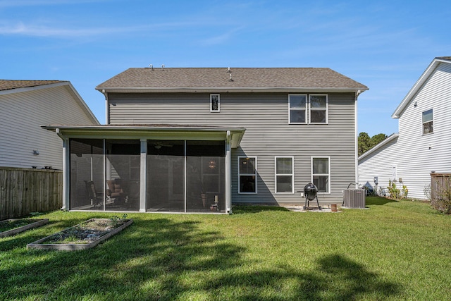 rear view of house featuring central air condition unit, a yard, and a sunroom