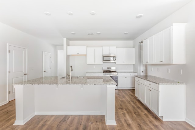 191 E Pinckney St, Summerville, SC 29485 - kitchen featuring appliances with stainless steel finishes, a sink, an island with sink, wood finished floors, and white cabinets