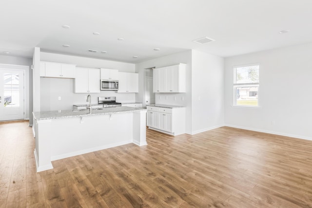 191 E Pinckney St, Summerville, SC 29485 - kitchen featuring stainless steel appliances, a sink, light wood-type flooring, white cabinets, and recessed lighting