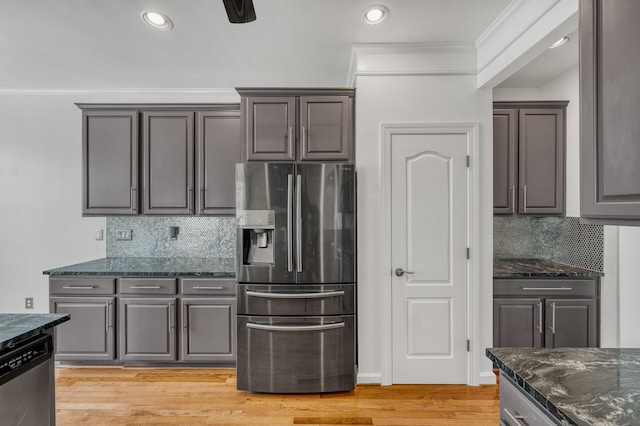 kitchen featuring dark stone counters, light hardwood / wood-style floors, backsplash, and stainless steel appliances