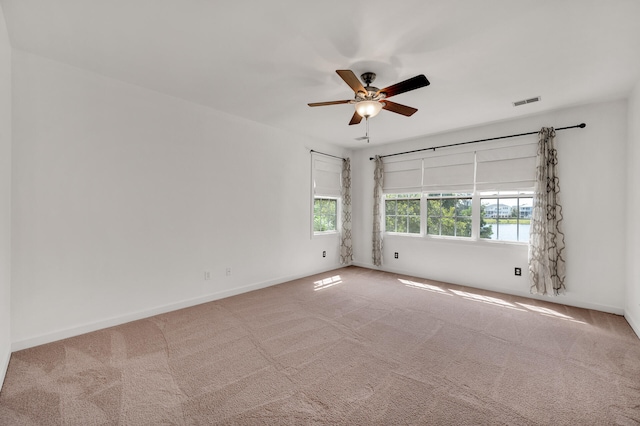 empty room featuring ceiling fan and carpet