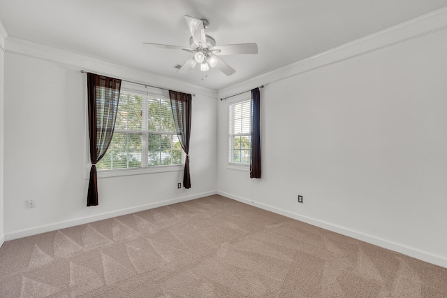 carpeted spare room featuring ornamental molding, ceiling fan, and plenty of natural light