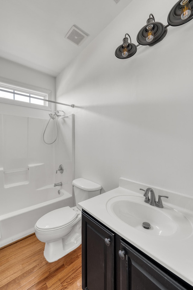 full bathroom with vanity, shower / bath combination, hardwood / wood-style floors, and toilet