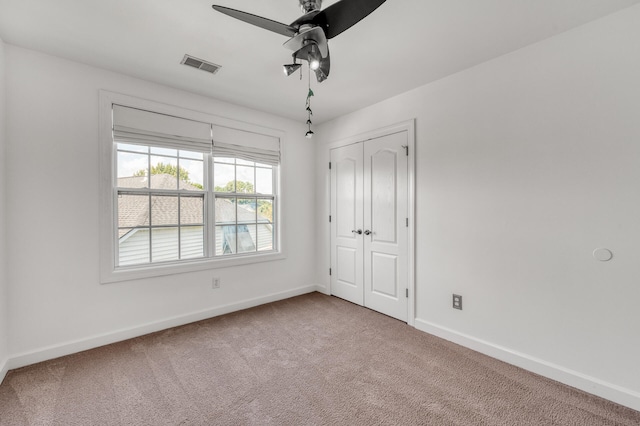 unfurnished bedroom with ceiling fan, carpet floors, and a closet