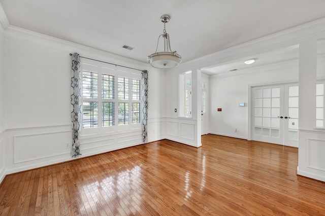 empty room featuring ornamental molding and hardwood / wood-style floors