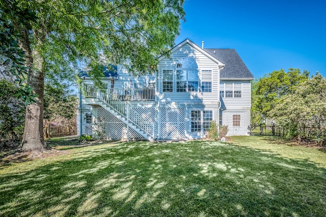 rear view of house with a wooden deck and a yard