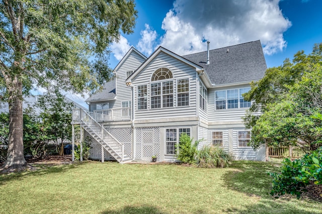 rear view of house with a lawn and a wooden deck