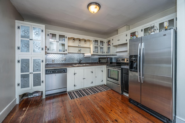 kitchen with sink, backsplash, white cabinetry, stainless steel appliances, and dark hardwood / wood-style floors