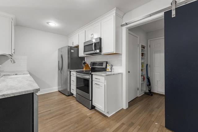 1445 Downwood Pl, Charleston, SC 29412 - kitchen with appliances with stainless steel finishes, a sink, light wood-style flooring, light countertops, and white cabinets