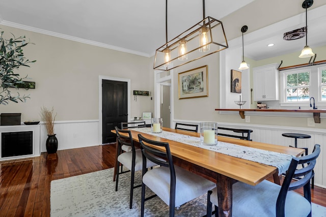 dining space featuring ornamental molding and dark wood-type flooring