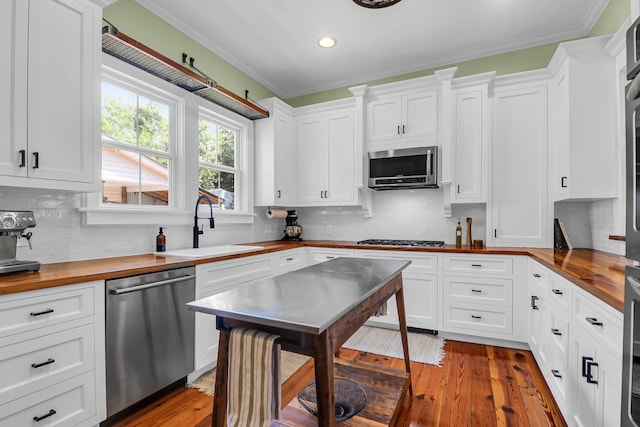 kitchen with tasteful backsplash, dark hardwood / wood-style floors, butcher block countertops, and stainless steel appliances