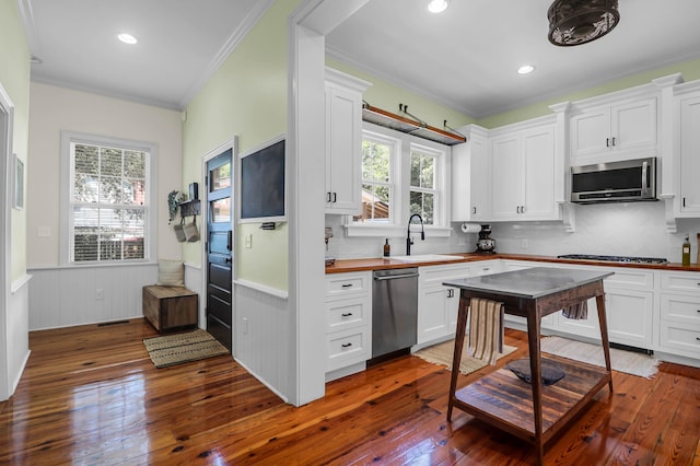 kitchen with tasteful backsplash, sink, stainless steel appliances, and hardwood / wood-style flooring