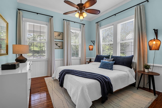 bedroom with dark wood-type flooring, ornamental molding, and multiple windows