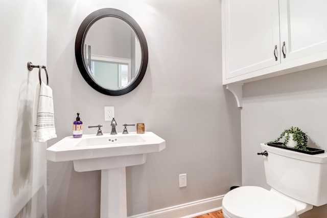 bathroom with toilet and hardwood / wood-style flooring