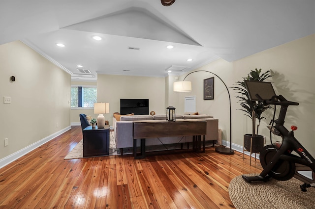 living room with lofted ceiling, crown molding, and hardwood / wood-style flooring