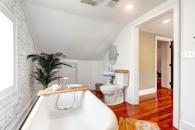 bathroom with wood-type flooring, toilet, and vaulted ceiling