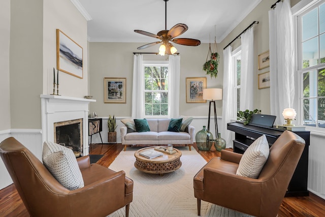 living room with hardwood / wood-style floors, ornamental molding, and ceiling fan