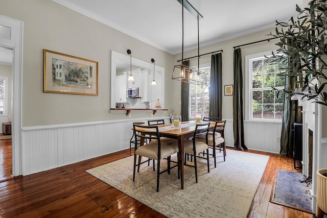 dining area with ornamental molding and hardwood / wood-style floors