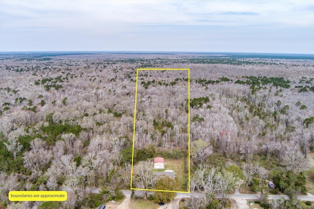 aerial view of property's location featuring property parcel outlined and a heavily wooded area