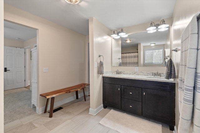 bathroom featuring double vanity and baseboards