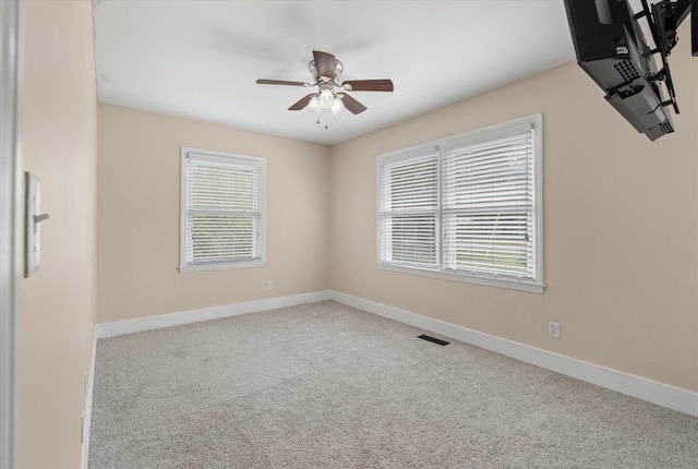 spare room with ceiling fan, baseboards, and carpet floors
