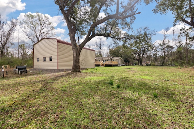 view of green lawn featuring a deck