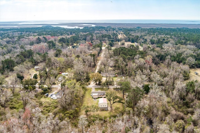 aerial view of property's location with a heavily wooded area and a nearby body of water
