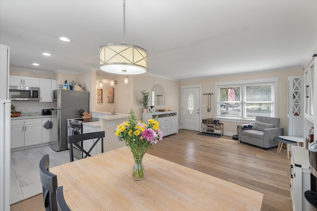 dining space with crown molding, recessed lighting, and light wood-style flooring