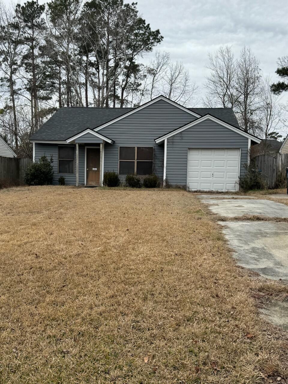 ranch-style house with a garage and a front yard