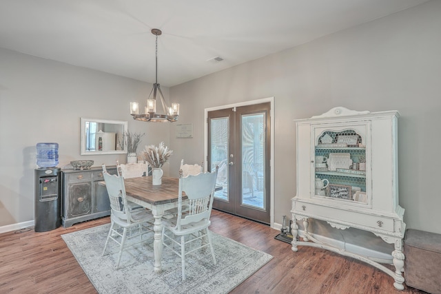 dining area featuring baseboards, visible vents, wood finished floors, and french doors