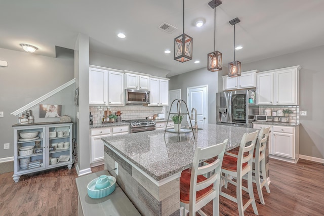 kitchen featuring dark wood-style floors, visible vents, appliances with stainless steel finishes, and white cabinets