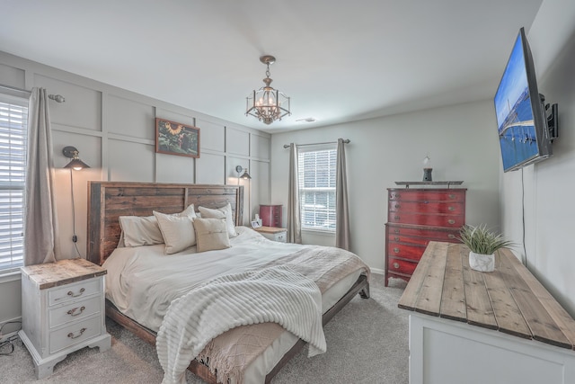 bedroom featuring carpet flooring, visible vents, and a notable chandelier