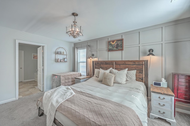 bedroom with light carpet, baseboards, a notable chandelier, and a decorative wall