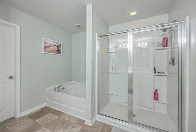 full bath with a shower stall, a bath, and baseboards