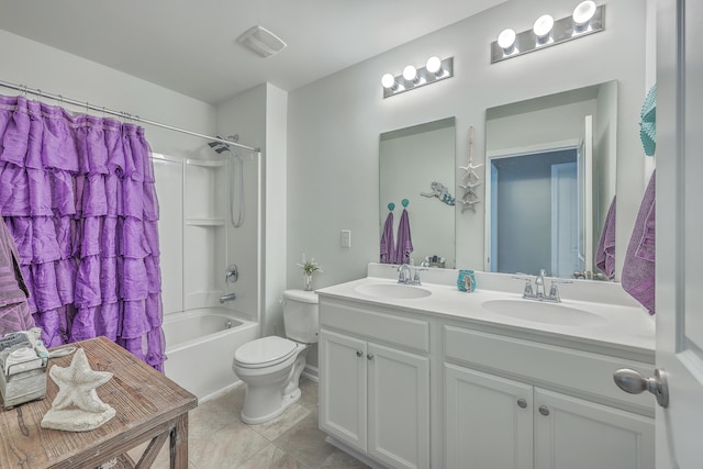 bathroom featuring toilet, double vanity, visible vents, and a sink