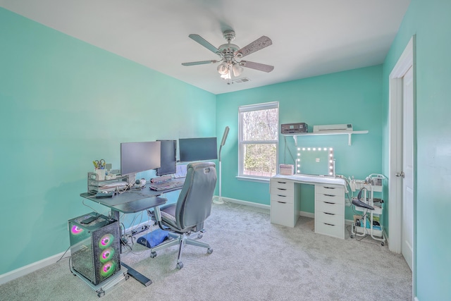 office area with baseboards, visible vents, a ceiling fan, and light colored carpet