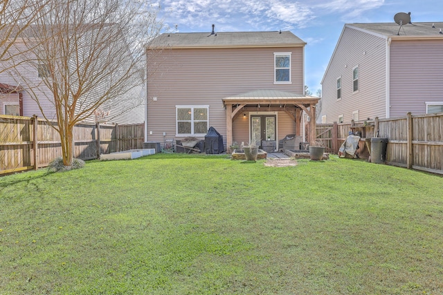 back of property featuring a fenced backyard, a lawn, and french doors