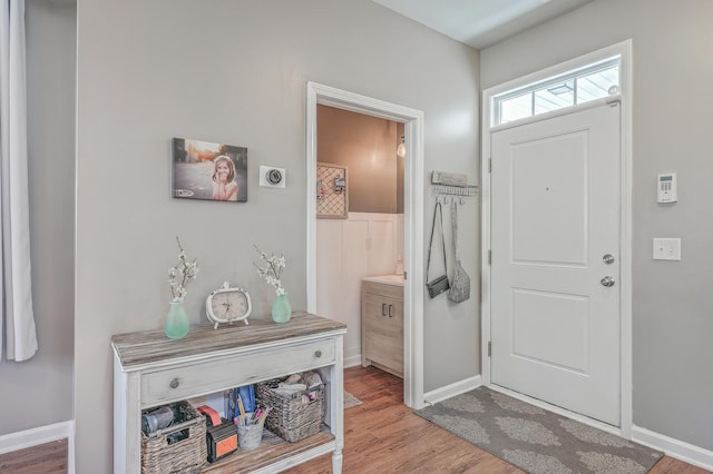 foyer featuring wood finished floors and baseboards