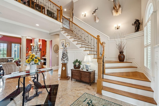 2834 Parkers Landing Rd, Mount Pleasant, SC 29466 - staircase featuring a decorative wall, ornate columns, crown molding, marble tiled floors, and wainscoting