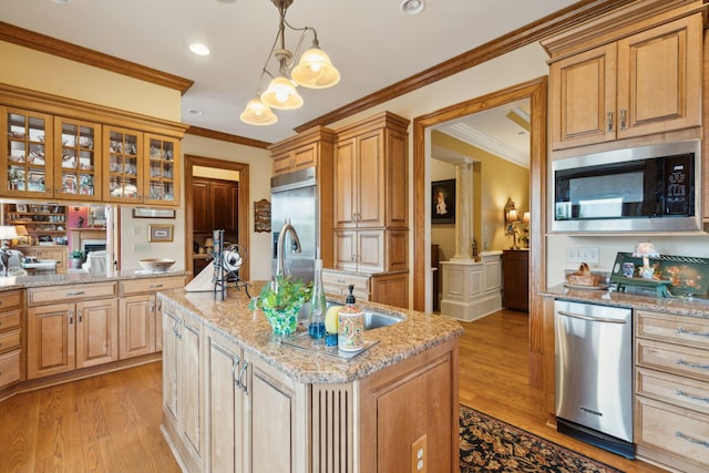 2834 Parkers Landing Rd, Mount Pleasant, SC 29466 - kitchen with built in appliances, a kitchen island with sink, light wood-type flooring, light stone counters, and crown molding