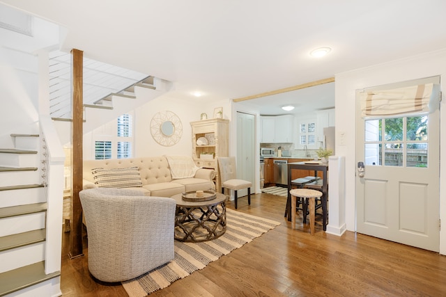 living room with ornamental molding and light wood-type flooring