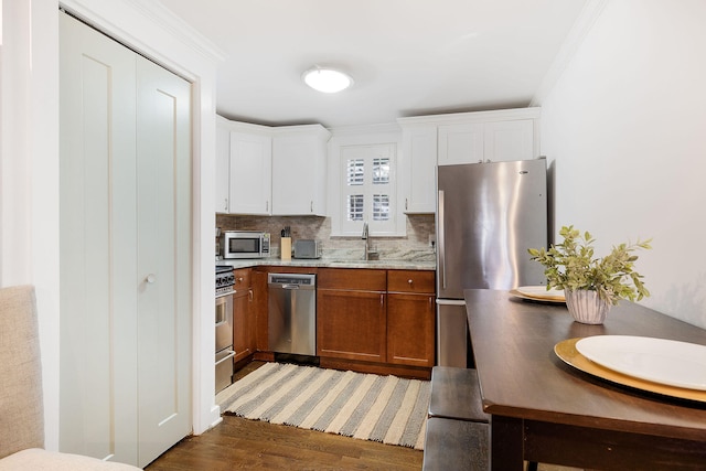 kitchen featuring sink, decorative backsplash, dark hardwood / wood-style flooring, white cabinetry, and stainless steel appliances