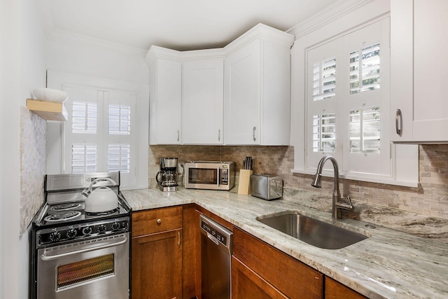 kitchen with white cabinetry, sink, crown molding, decorative backsplash, and appliances with stainless steel finishes