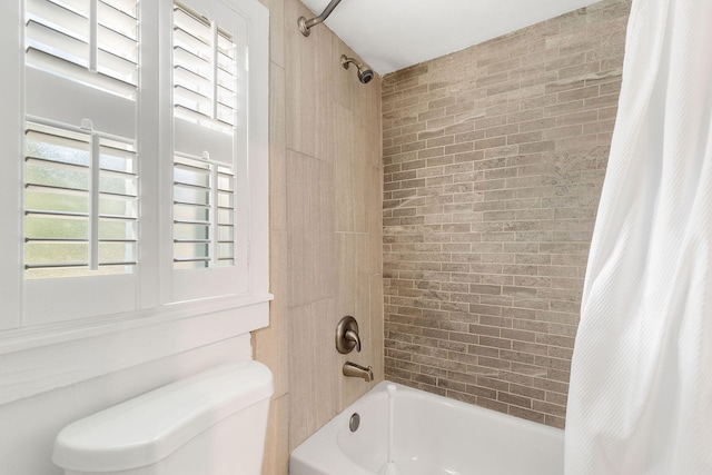 bathroom with toilet, shower / bath combo with shower curtain, and a wealth of natural light