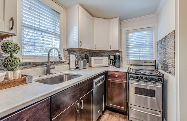 kitchen featuring backsplash, white cabinets, sink, appliances with stainless steel finishes, and dark brown cabinetry