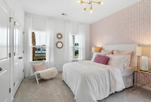 bedroom featuring light colored carpet and a notable chandelier