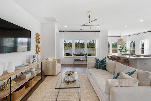 living room featuring hardwood / wood-style flooring, a chandelier, and sink