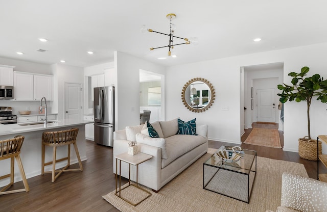 living room with sink, hardwood / wood-style floors, and an inviting chandelier