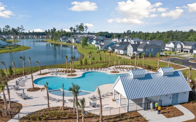 view of swimming pool with a patio and a water view